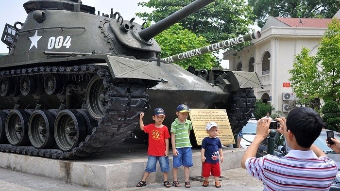 Children pose in front of a tank on display in the courtyard of the Vietnam Military History Museum (Photo: giaoduc.net.vn)