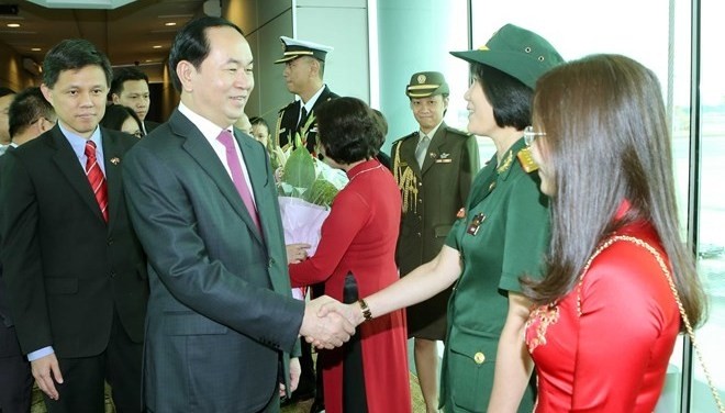 President Tran Dai Quang (L) is welcomed at Changi international airport. (Photo: VNA)