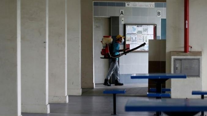 A worker sprays insecticide along the common areas of a public housing estate at an area where locally transmitted Zika cases were discovered in Singapore August 30, 2016. (Credit: Reuters)