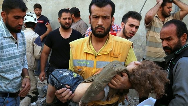 A medic holds a dead child after airstrikes on the rebel-held Karam Houmid neighbourhood of Aleppo, Syria on October 4, 2016. (Credit: Reuters)