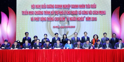 Vice President Dang Thi Ngoc Thinh and Hanoi leaders witness the signing of commitments to implementing support programmes for national revolutionary contributors.