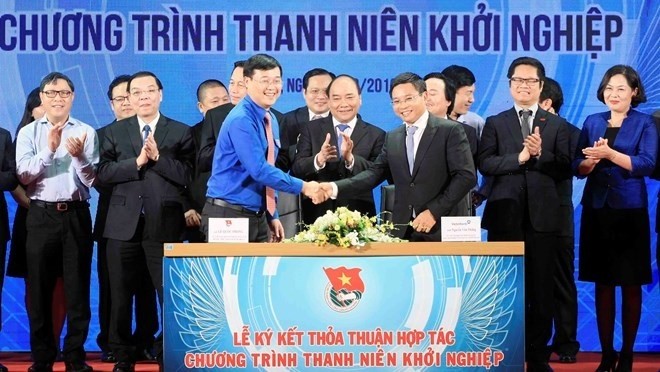 Prime Minister Nguyen Xuan Phuc (centre) witnesses the signing of cooperation on start-up support between the Central Committee of the Ho CHi Minh Communist Youth Union and businesses (Photo: VNA)