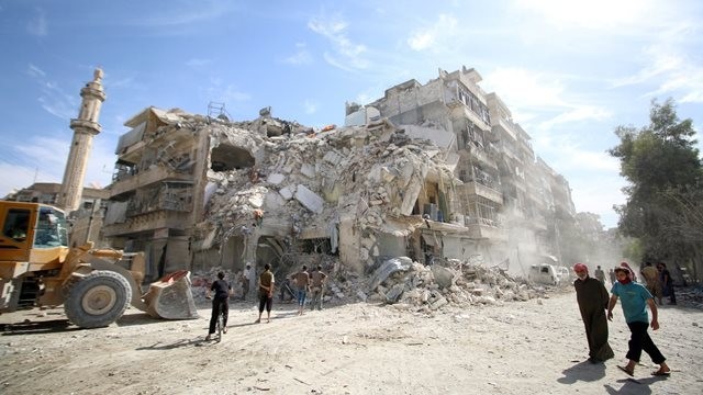 People inspect a damaged site after an air strike Sunday in the besieged rebel-held neighbourhood of al-Qatirji in Aleppo, Syria on October 17, 2016. (Credit: Reuters)