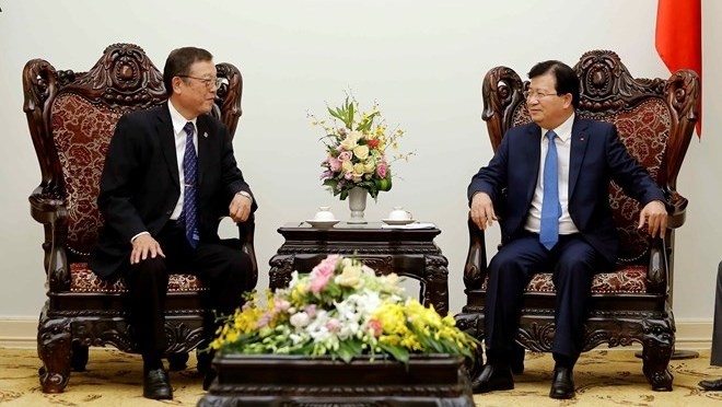 Deputy Prime Minister Trinh Dinh Dung (R) meets with President of Devnet Japan Fumiyasu Akegawa on October 21 (Photo: VNA)