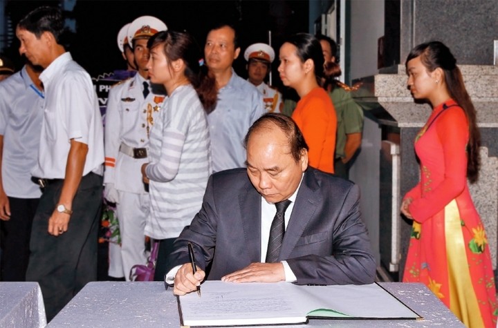 PM Nguyen Xuan Phuc writes in the book of condolences.