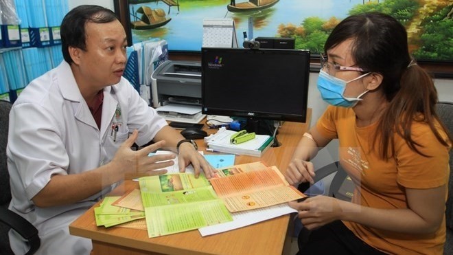 A patient is hearing doctor's consultation (Photo: VNA)