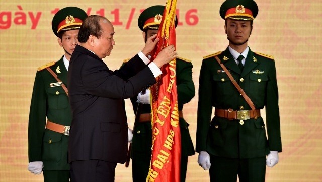 PM Nguyen Xuan Phuc pins the Labour Order, first class, to the university's traditional flag at a ceremony to mark its 60th anniversary in Hanoi on November 12. (Credit: VGP)
