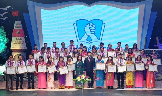 Politburo member Truong Thi Mai poses for a photo with the honoured teachers.