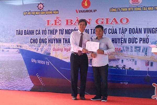 Vingroup Vice President Le Khac Hiep (left) presents the vessel to fisherman Huynh Thach.