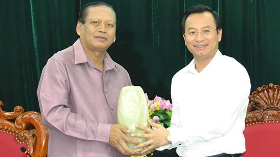 Secretary of the Da Nang Party Committee Nguyen Xuan Anh (right) presents a souvenir to Champasak Governor Bounthong Divixay.