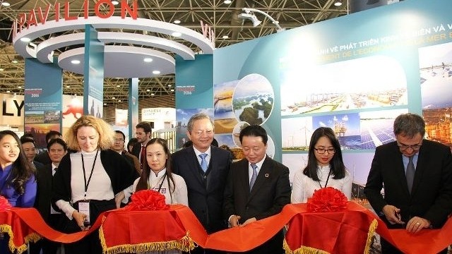 Minister of Natural Resources and Environment Tran Hong Ha cuts the ribbon to open the Vietnamese booth at the exhibition.