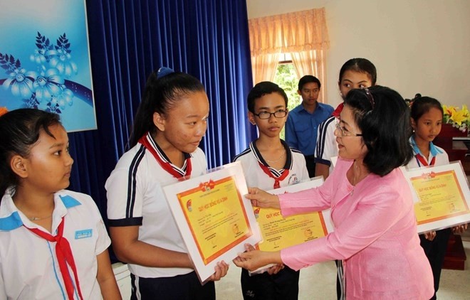 Representative from Vu A Dinh Fund presents scholarship for students. (Photo: VNA)