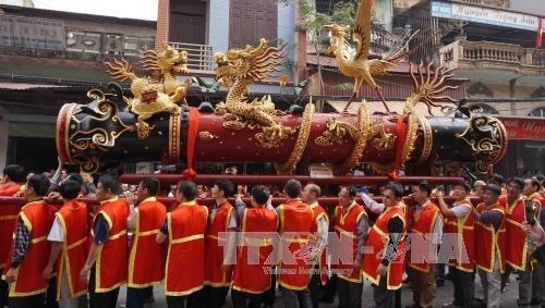 A giant firecracker model being carried during the festival. (Photo: VNA)