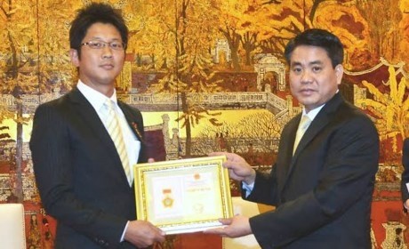 Chairman of the Hanoi People’s Committee Nguyen Duc Chung (R) award​s “For the cause of Hanoi” title to Fukushima Yosuke, First Secretary of the Japanese Embassy in Vietnam. (Photo: kinhtedothi.vn)