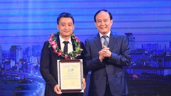 Vice Chairman of Hanoi People's Council Standing Committee Nguyen Ngoc Tuan presents an award to author Dinh Quoc Thai, the overall winner of the 2016 competition.