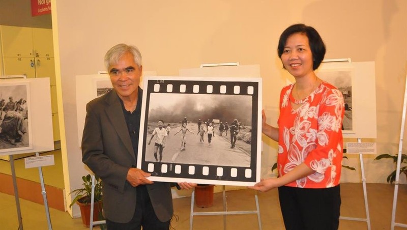 Photographer Nick Ut presents his 'Napalm Girl' photo to the Director of the Vietnamese Women’s Museum (Photo: baotangphunu.org.vn)