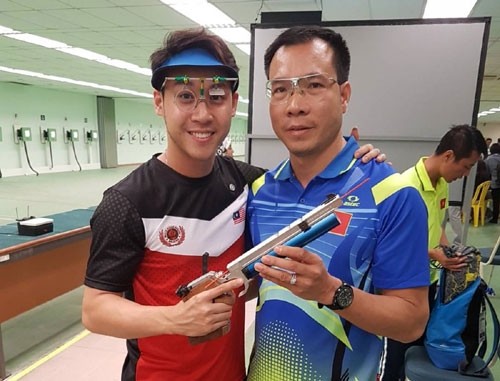 Hoang Xuan Vinh (right) after the men's 10m air pistol final competition.