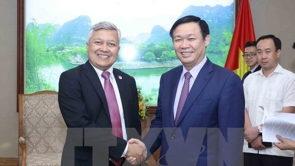 Deputy Prime Minister Vuong Dinh Hue (R) and Indonesian Ambassador to Vietnam Ibnu Hadi