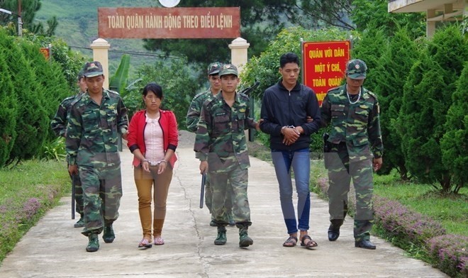Border guards of Lai Chau province escort two human traffickers (Photo: VNA)
