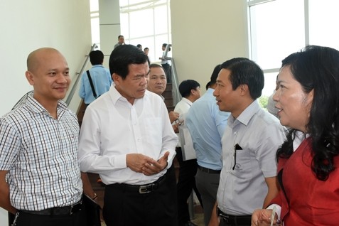 Secretary of the provincial Party Committee, Nguyen Hong Linh (in white), talks with businesses at the conference.