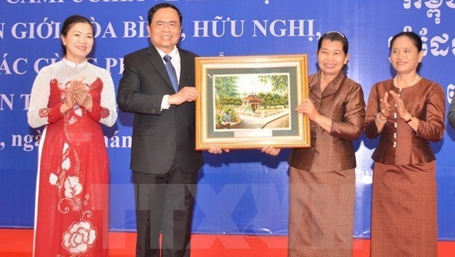 President of the VFF Central Committee Tran Thanh Man (second from left) presents gift to Men Sam Ol (second from right) (Source: VNA)