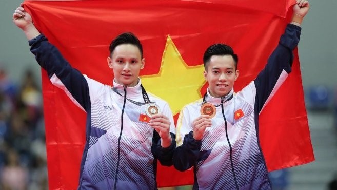 Dinh Phuong Thanh and Le Thanh Tung take medals in the horizontal bar event.