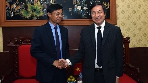 Nhan Dan Newspaper's Deputy Editor-in-chief Le Quoc Khanh (right) receives deputy head of the International Department of Paxaxon Newspaper Syvanh Homsayadeth. 