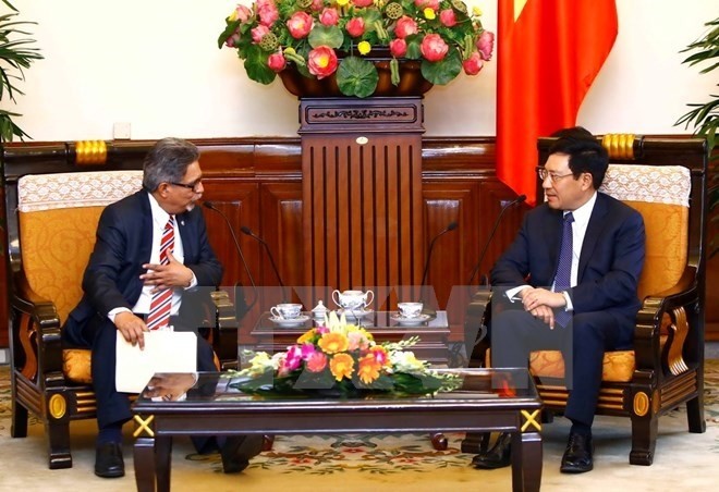 Deputy Prime Minister and Foreign Minister Pham Binh Minh (R) receives Deputy Foreign Minister Carlos Castaneda (Photo: VN