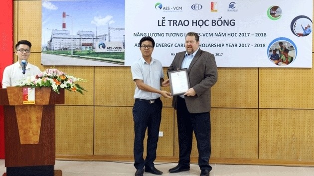 Managing Director of AES-VCM Mong Duong Power Company David Stone grants the AES-VCM Energy Career Scholarship to a student at the launch of the scholarship in Hanoi, on September 27.