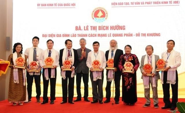 The organising committee presents symbolic models of Vietnam's national emblem to outstanding industrialists and entrepreneurs.