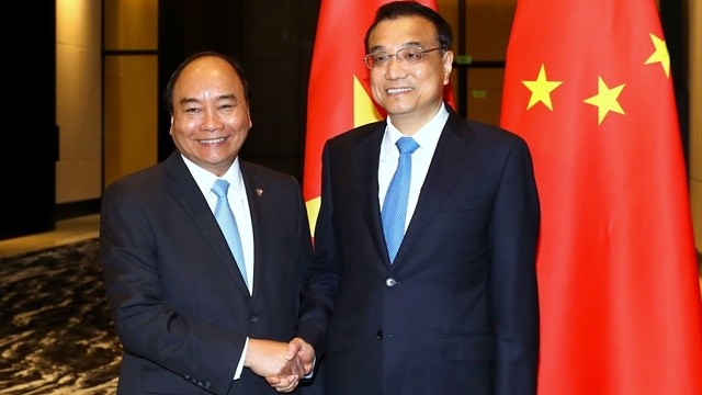 Vietnamese PM Nguyen Xuan Phuc (L) and Chinese Premier Li Keqiang in Manila, the Philippines, on November 13. (Credit: VGP)