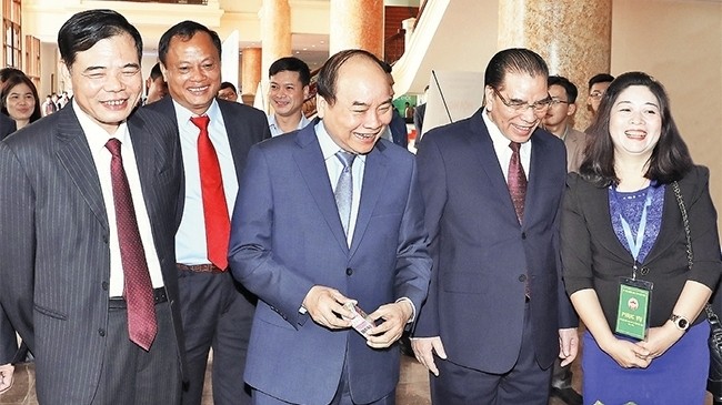 PM Nguyen Xuan Phuc and delegates visit a booth on the sidelines of the conference (Photo: VNA)