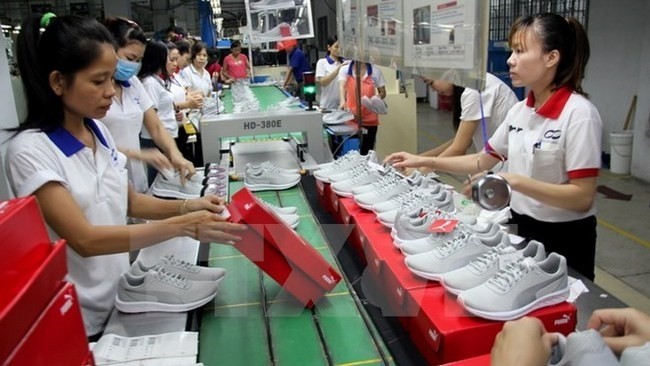 Producing footwear for export (Source: VNA)