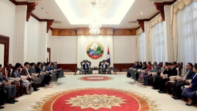 Lao PM Thongloun Sisoulith receives Vietnamese Minister of Planning and Investment Nguyen Chi Dung in Vientiane on December 16. (Credit: VNA)