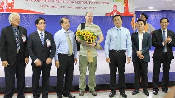 Leaders of Ho Chi Minh City Department of Tourism welcome Richard Kenneth Wilson, the first e-visa visitor to Vietnam. (Credit: sggp.org.vn)