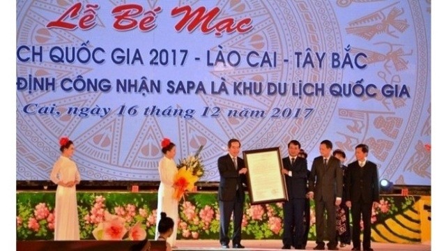 Lao Cai authorities receive the decision from the Prime Minister to recognise Sa Pa district as a national tourist area at the closing ceremony for the National Tourism Year 2017 on December 16. (Credit: NDO)