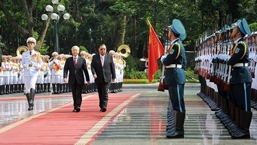 Vietnamese Party General Secretary Nguyen Phu Trong (L) and Lao Party General Secretary and President Bounnhang Volachith inspect the guard of honour during the latter's visit to Vietnam in April 2016