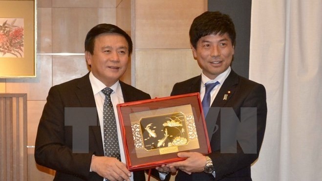  Japanese State Minister for Foreign Affairs Kazuyuki Nakane  presents a gift to Secretary of the CPV Central Committee Nguyen Xuan Thang (L).  (Photo: VNA)