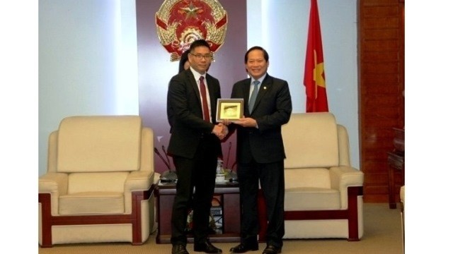 Minister of Information and Communications Truong Minh Tuan (R) presents a gift to Damian Yeo, head of legal and regulatory affairs for Facebook in the Asia Pacific region. (Credit: NDO)