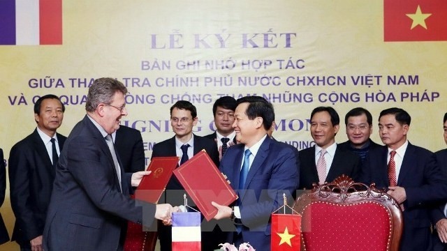 Government Inspector General Le Minh Khai and head of the French Anti-Corruption Agency Charles Duchaine sign the cooperation agreement on preventing and fighting corruption in Hanoi on January 15. (Credit: VNA)