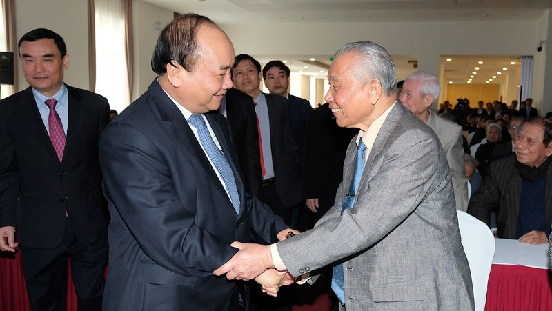Prime Minister Nguyen Xuan Phuc (L) salutes a retired Government Office official (Photo: VGP)