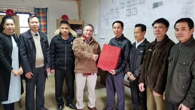 Vietnamese Ambassador to Algeria Pham Quoc Tru (C) offers the best New Year wishes and gifts to Vietnamese workers at Chinese KunLong construction company in Oulet Fayet new urban area in the outskirts of Algiers capital (Photo VNA)