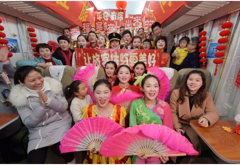 Attendants pose for a photo with passengers on the train Z68 from Nanchang, east China's Jiangxi Province to Beijing, capital of China, Feb. 13, 2018. A Spring Festival gala was held by the attendants on the train to bring happiness to the passengers. (Photo:Xinhua)