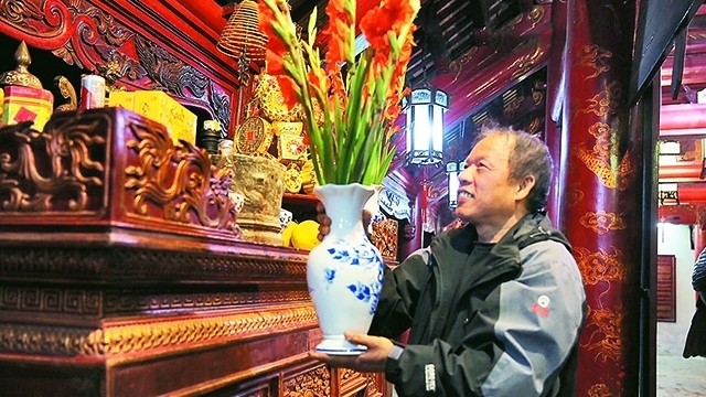 Do Ngoc Chung preparing the altar for the lunar New Year's Eve at Temple of Literature