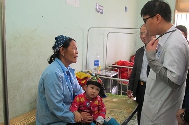 Doctor Do Phuong speaks with a child’s relative at the Pac Nam district health centre in Bac Kan province. 
