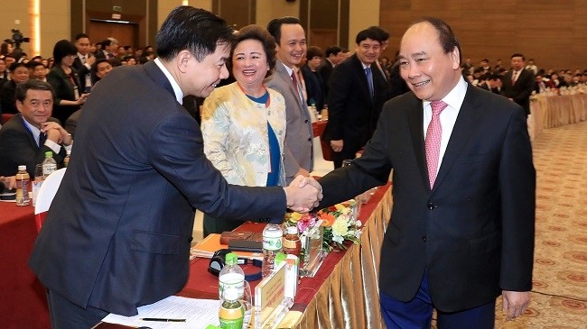 PM Nguyen Xuan Phuc shakes hand with investors at the meeting. (Photo: VGP)