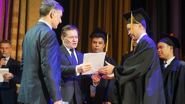 ROSATOM’s General Director Alexey Likhachev presents graduation certificates to Vietnamese students. 