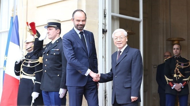 Secretary General of the Communist Party of Viet Nam Nguyen Phu Trong (R) shakes hands with French Prime Minister Édouard Philippe