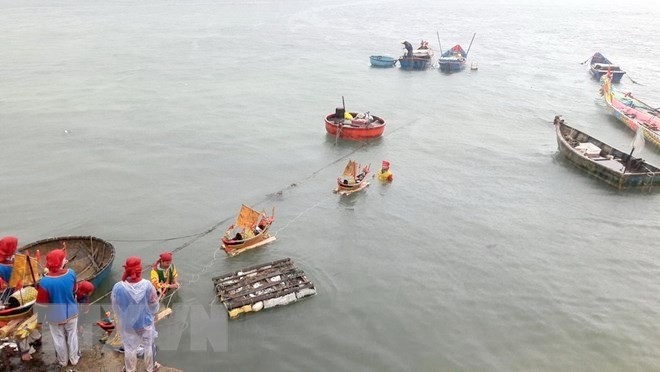 Boats with effigies of sailors are launched into the sea at the ceremony (Photo: VNA)