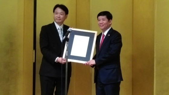 Vietnamese Ambassador to Japan Nguyen Quoc Cuong (R) presents the appointment decision to Japanese doctor Nagato Natsume.
